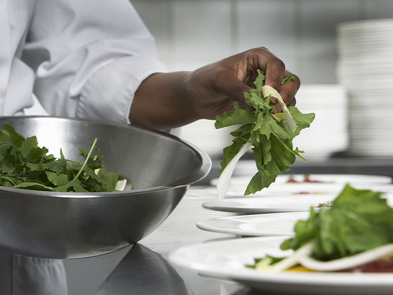 Student making a salad in culinary class.