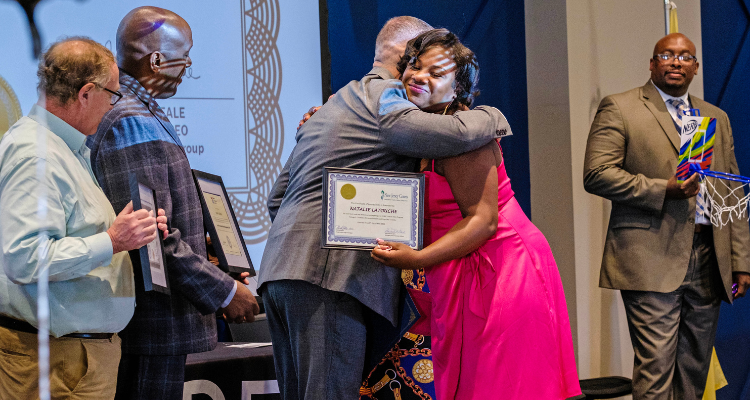Apex cohort graduate receives her certificate during graduation ceremony 