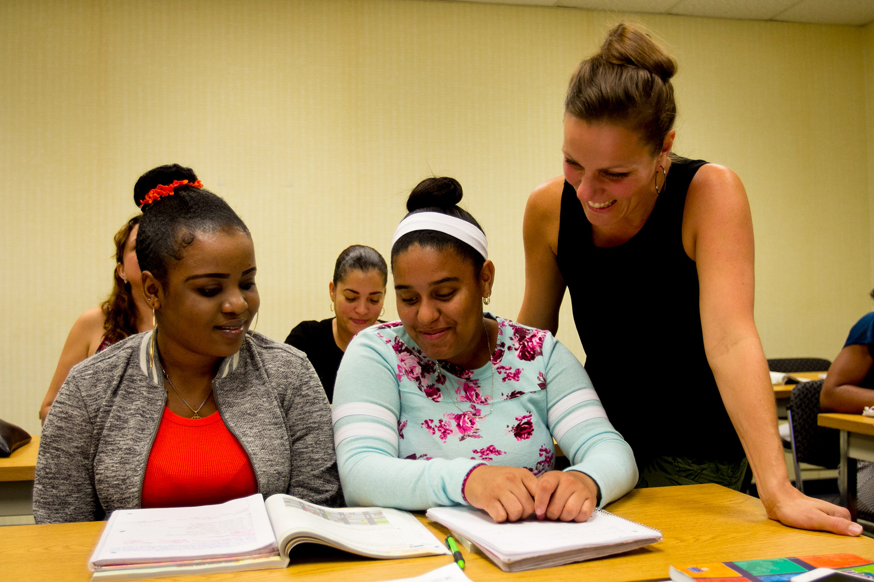 ESL classroom,  teacher and two students interacting