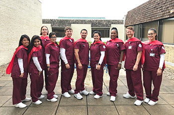 A group of nurses stand together in front of a building