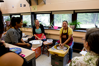 Women sit and make Pottery 