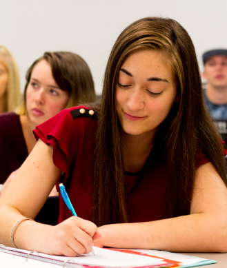 A girl at a desk writing something