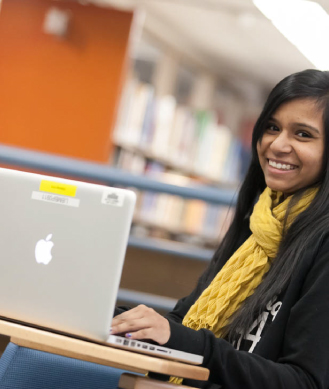 smiling lady with a scarf on her laptop