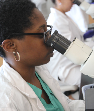 African American lady looking through a microscope