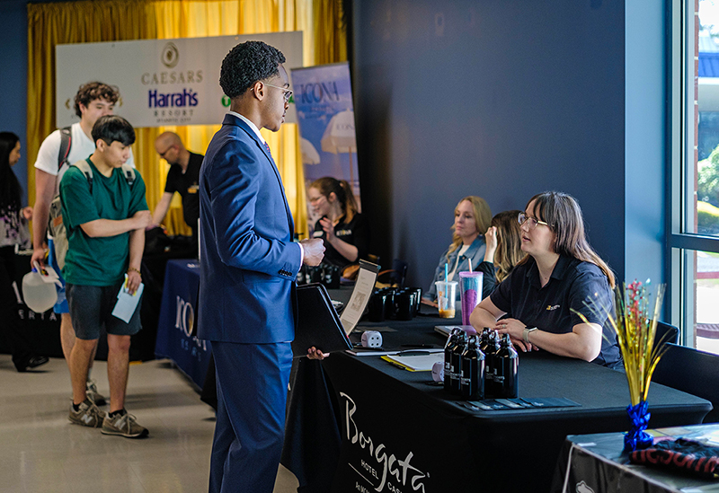 student speaks with employer at career fair