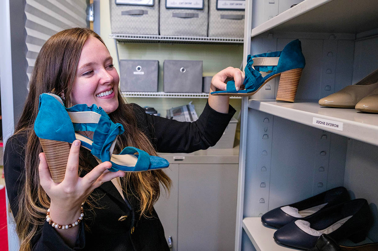 Student picking out a pair of blue shoes.