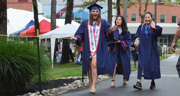 Atlantic Cape Community College 2022 graduate walks across the quad at the Mays Landing campus before Commencement.