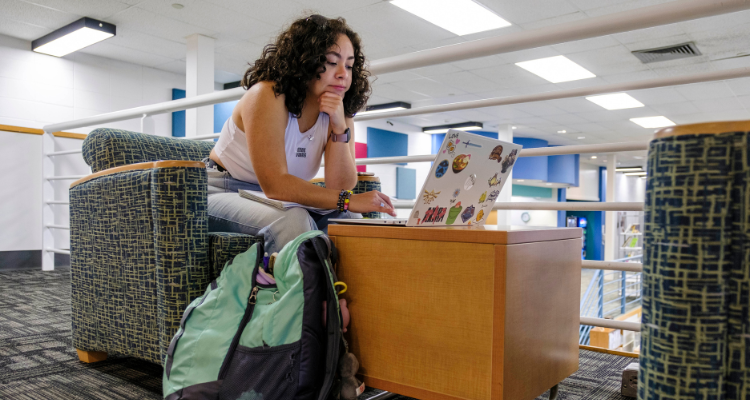 Student browses on laptop in hallway of Mays Landing campus on the first day of fall classes.