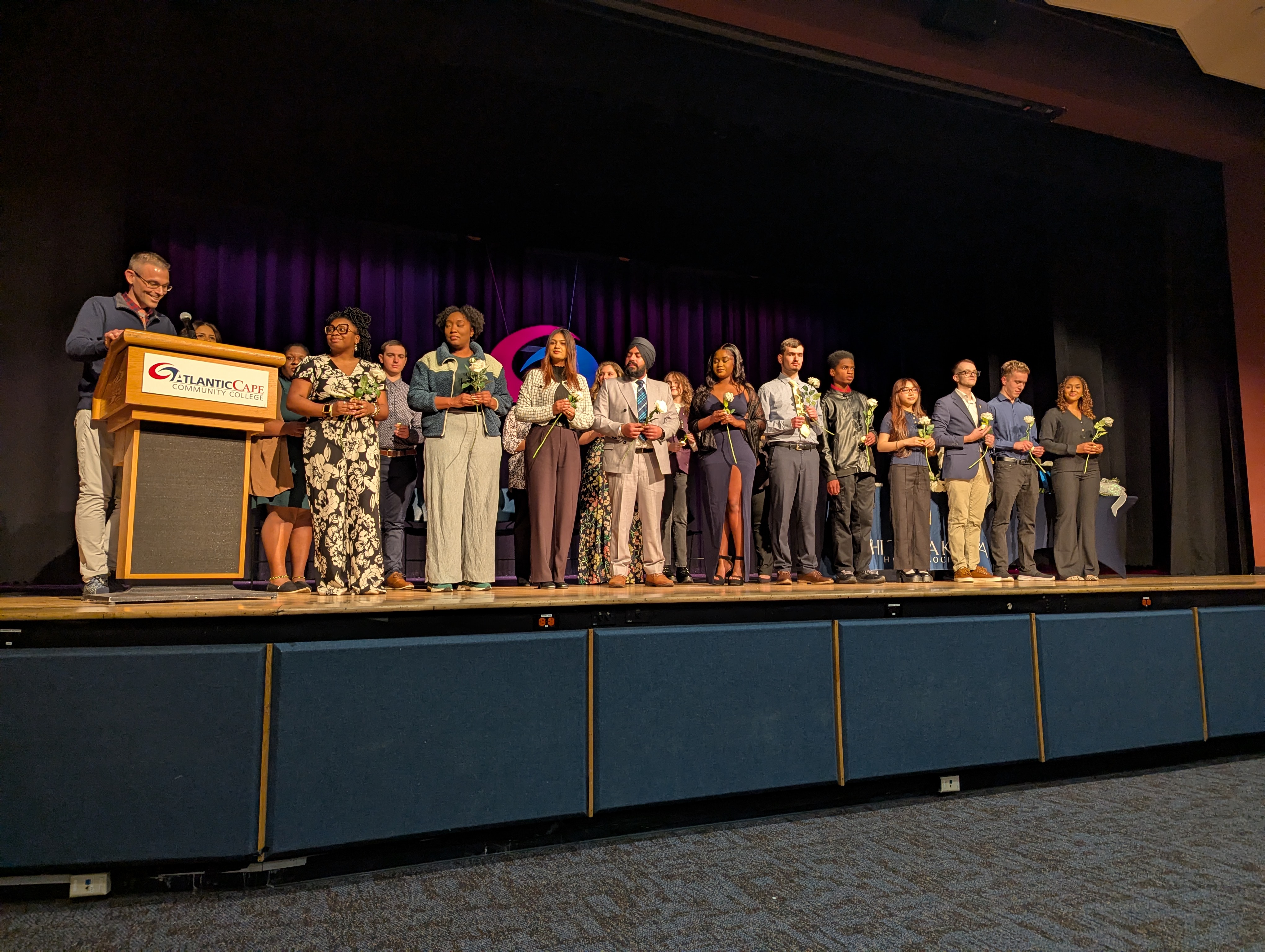PTK members inducted pose for photo on stage