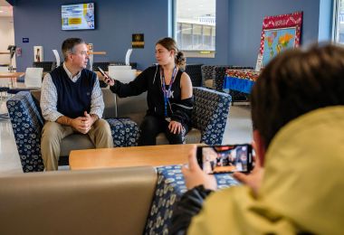 A high school student interviews Scott Grayson during Media Day