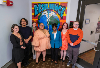 Dr Barbara Gaba, Artist Nadaijia Hall and members of Atlantic Cape's Art Club stand in front of the Resilience painting