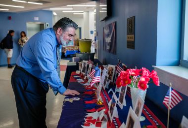 Financial Aid Assistant Director Dominic Tullio looks at photos of veterans on display